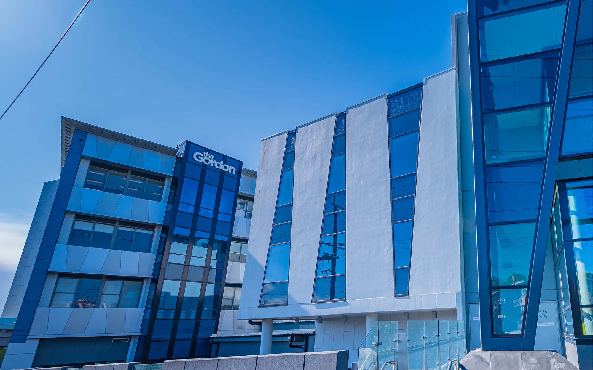 Image of the City Campus buildings looking north - an architecturally complex against a blue sky.