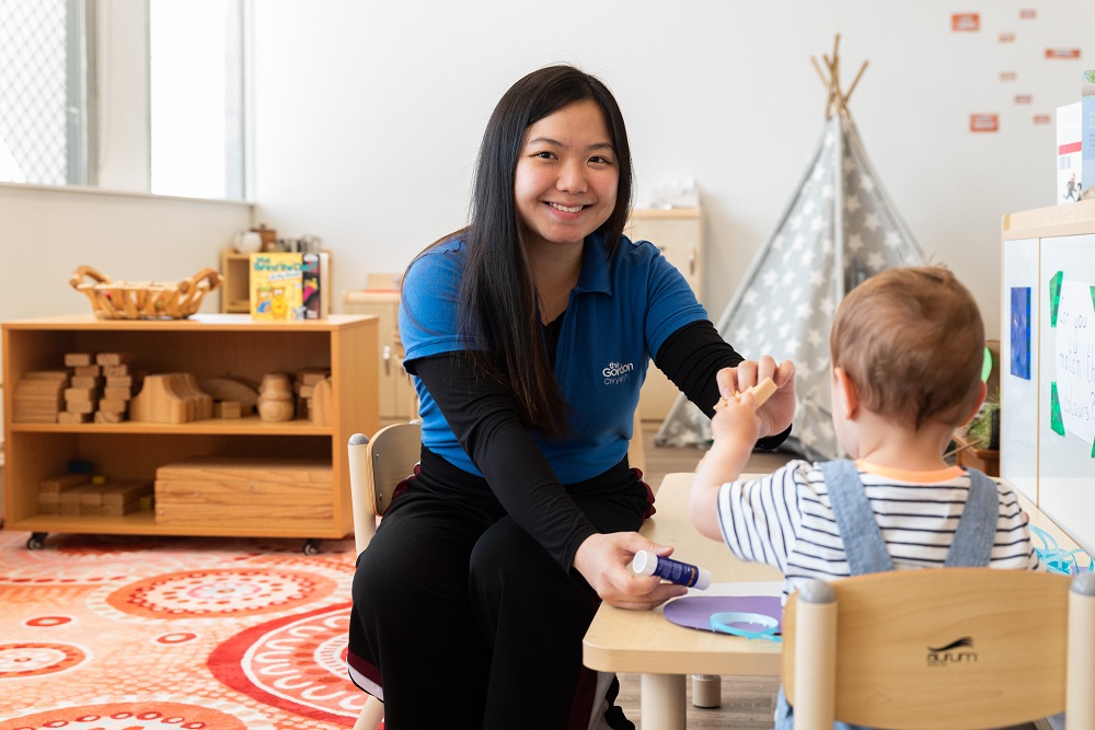 Image of a smiling international student in a child care environment.