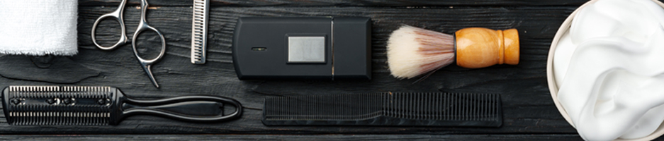 Tools of the barbering trade; including comb, foam brush and electric razor.
