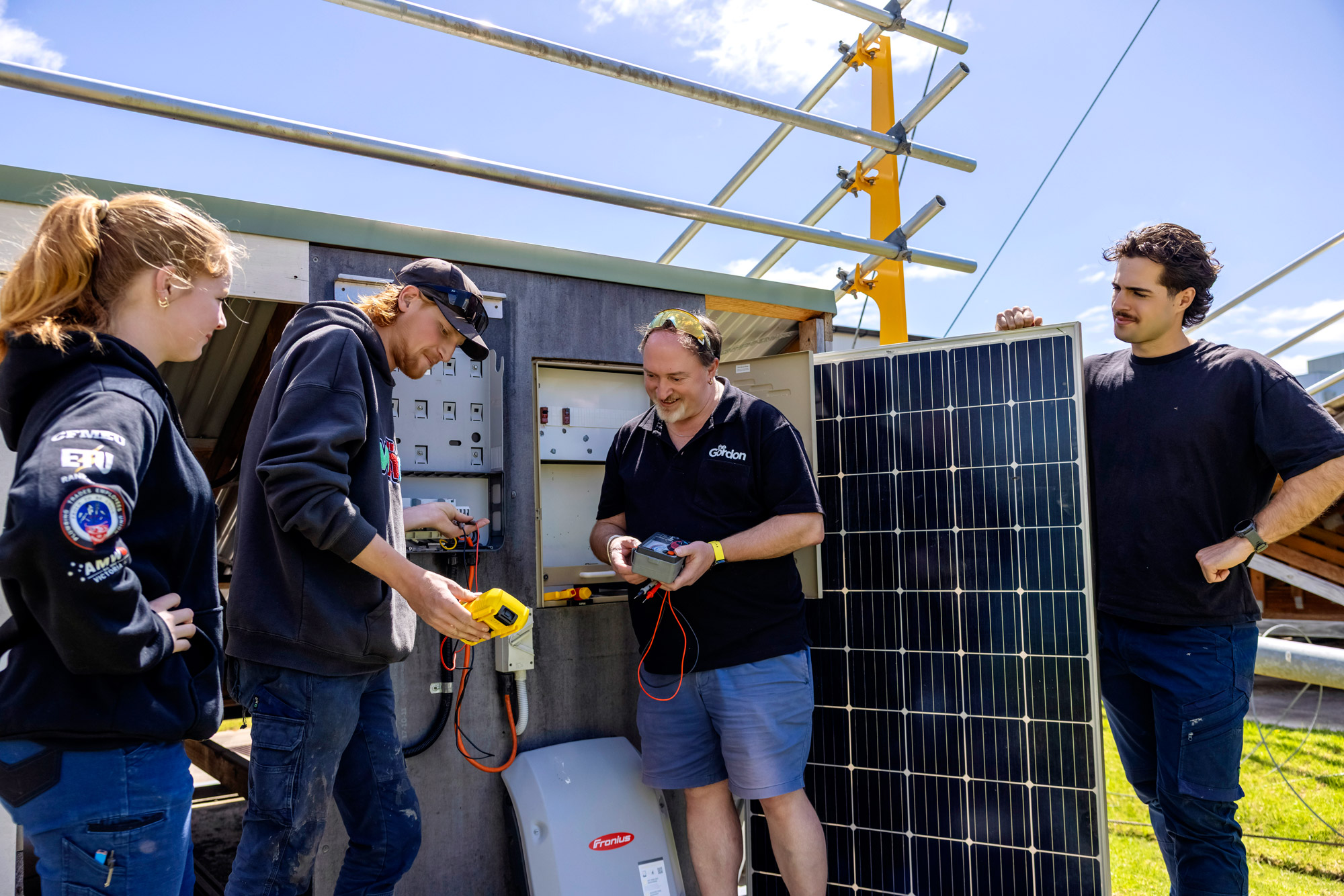 Image of electrical students and their instructor working on an main board installation