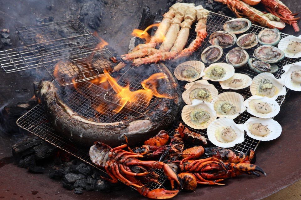Image of sea food being cooked over an open flame