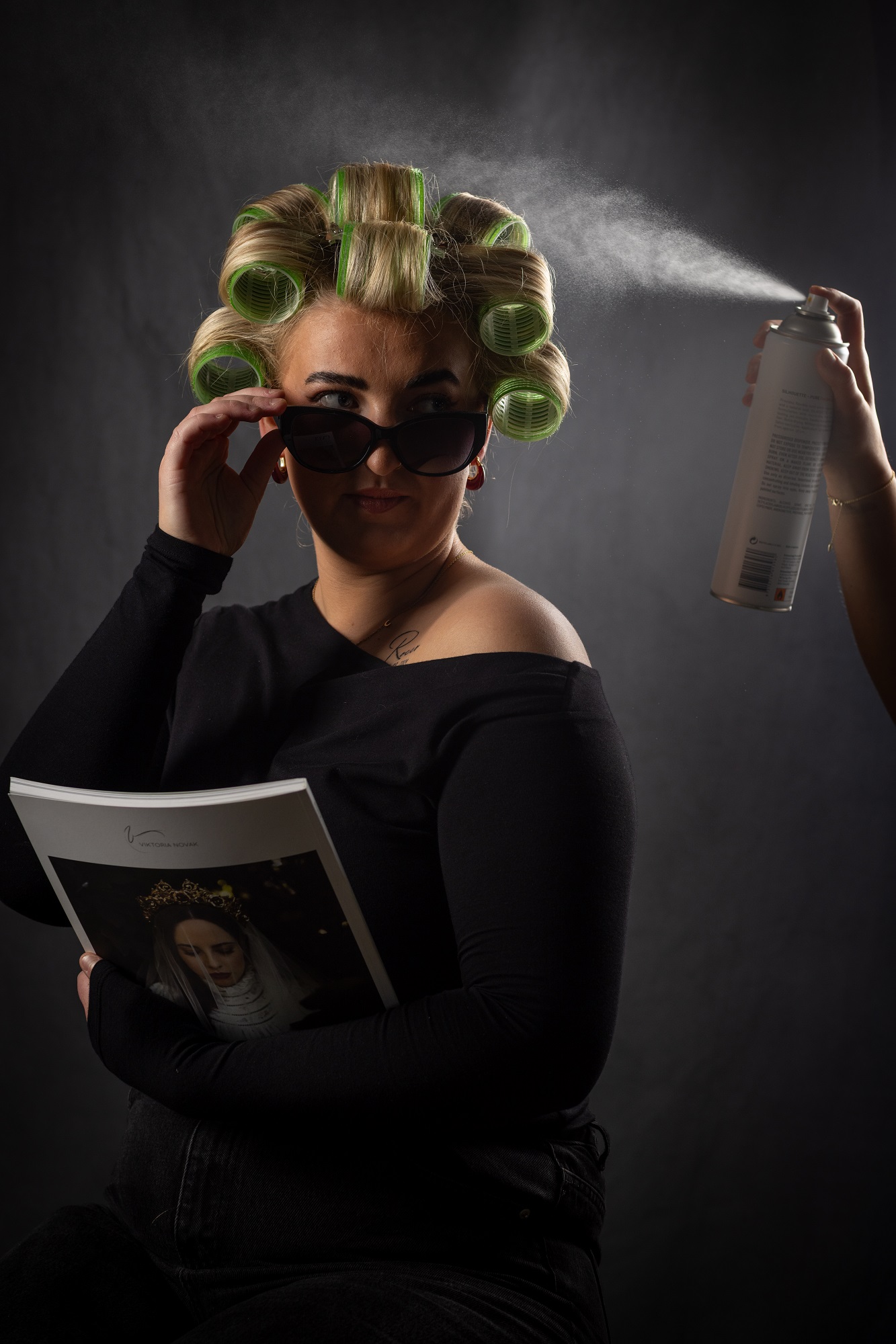 Model looking cool with sun glasses, with hair in ringlets, being sprayed with water mist.
