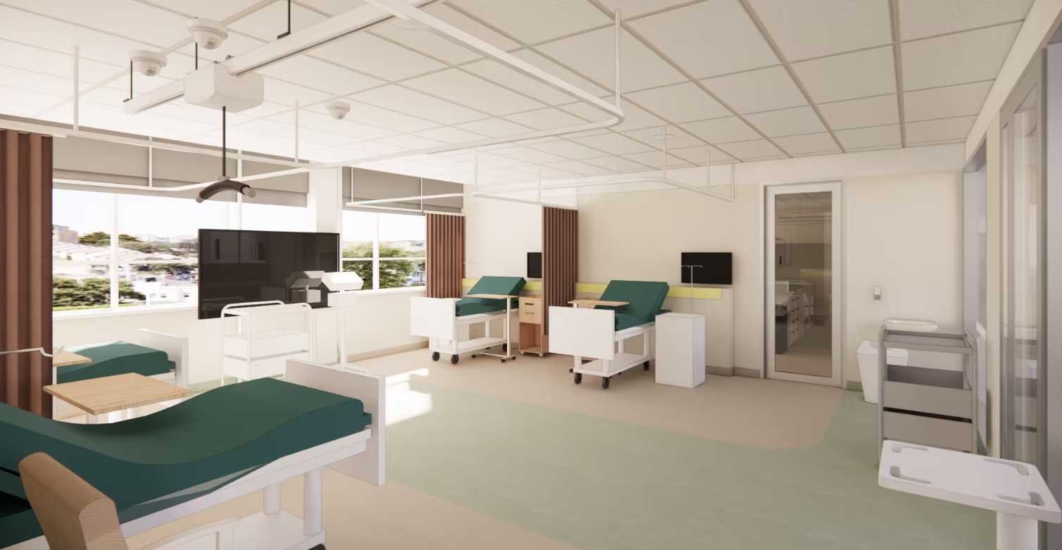 Bright training room with hospital beds, seating and large screens.