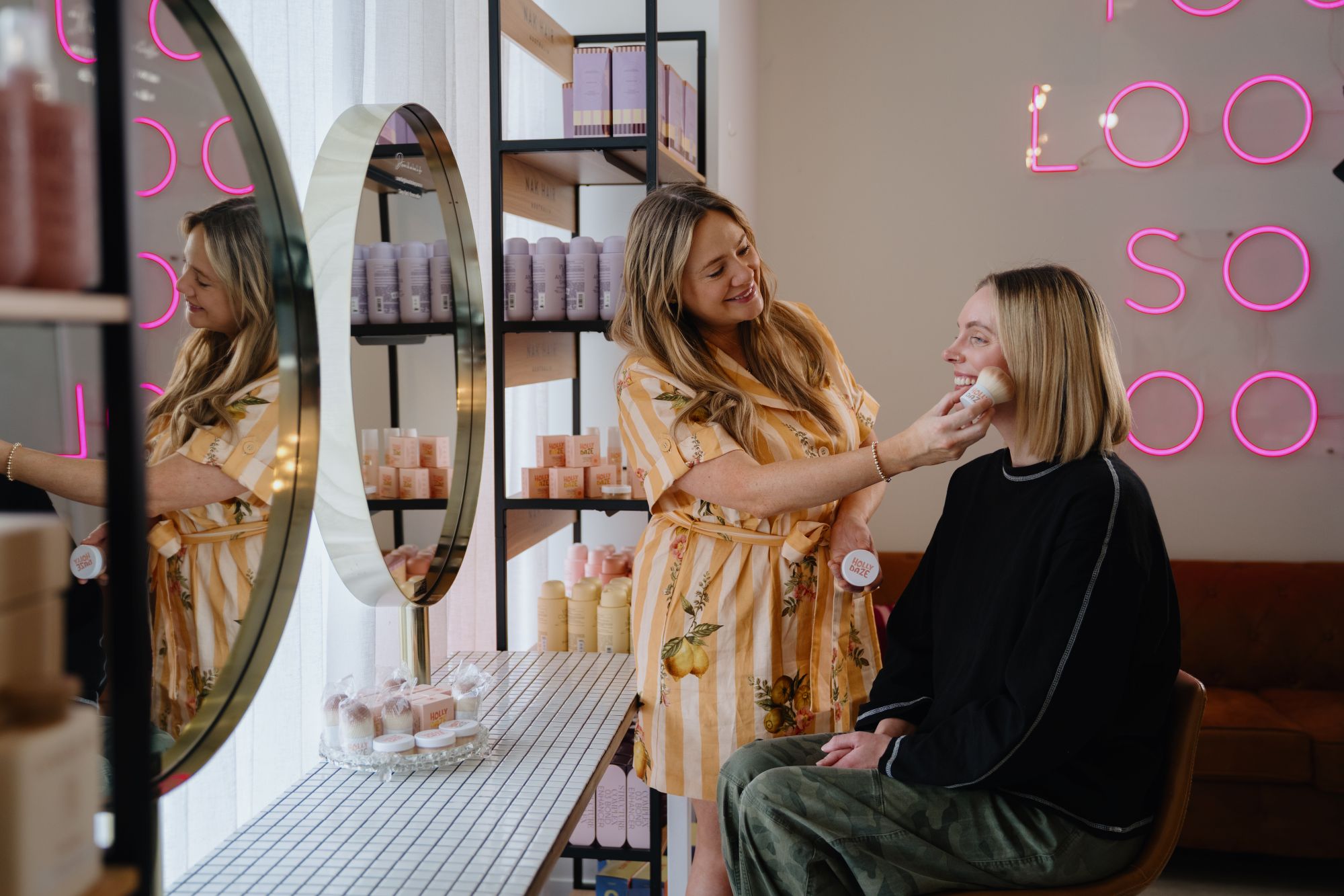 Image of Kayla Houlihan applying skin care products to another persons face.