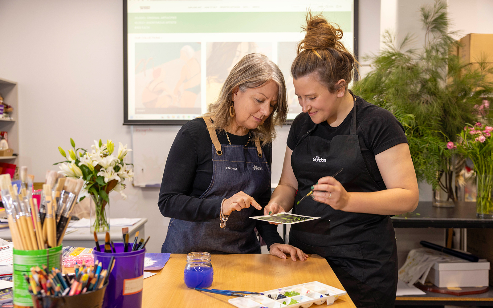 Image of Floristry Student Emma Wheatland with her teacher. They are studying a color palatte.
