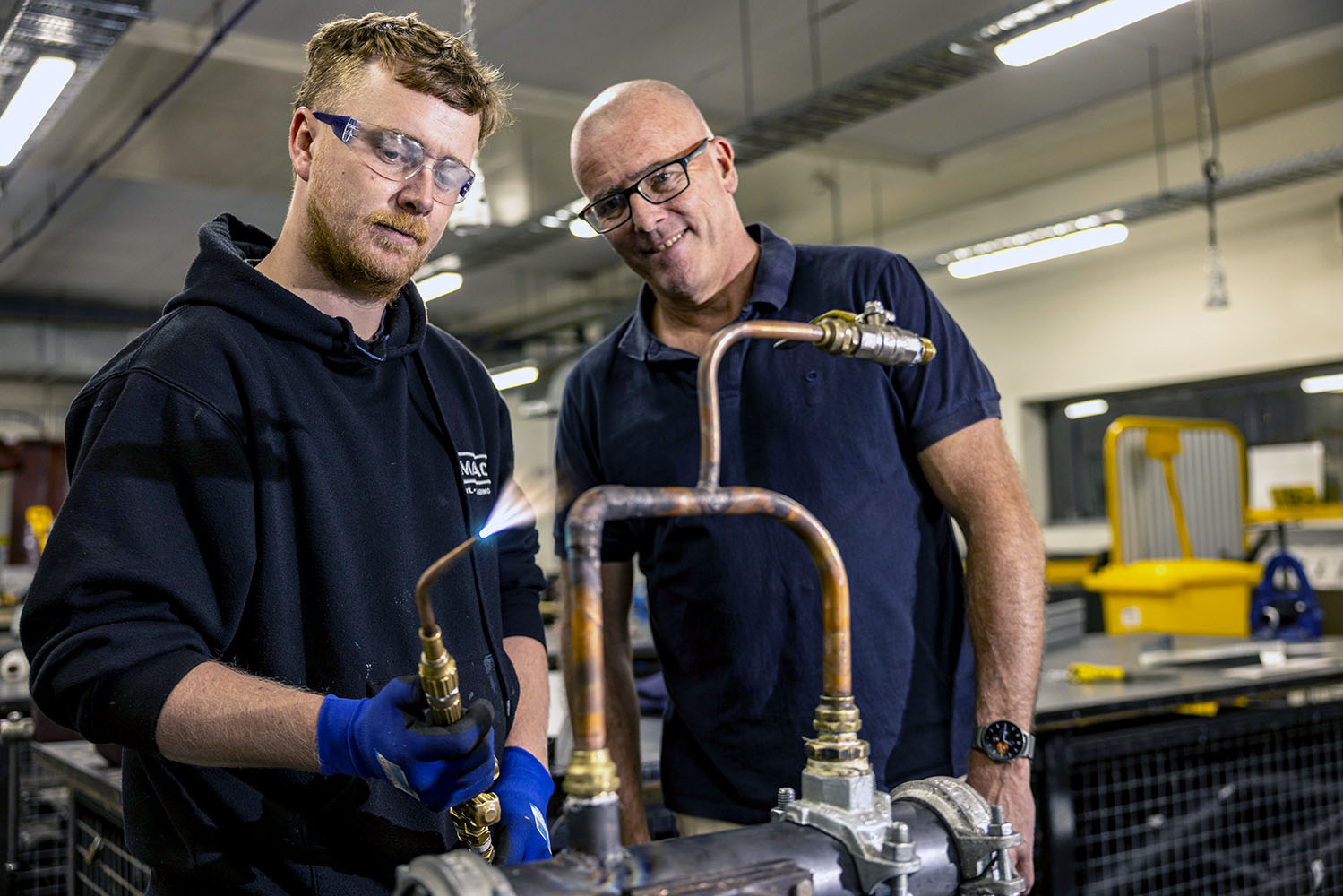 Image of Trades student with teacher engaged in plumbing training