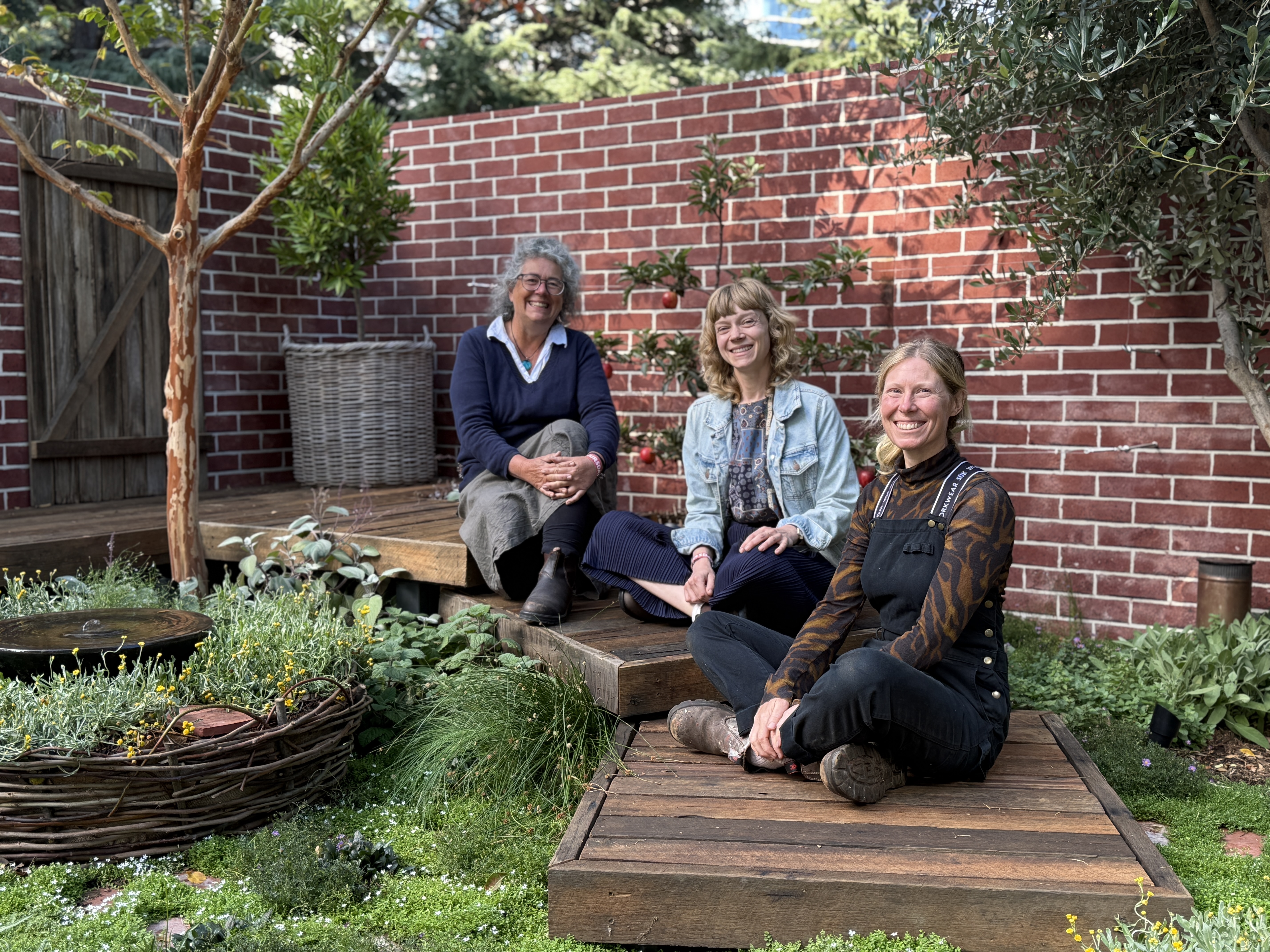 students sitting in their designed garden