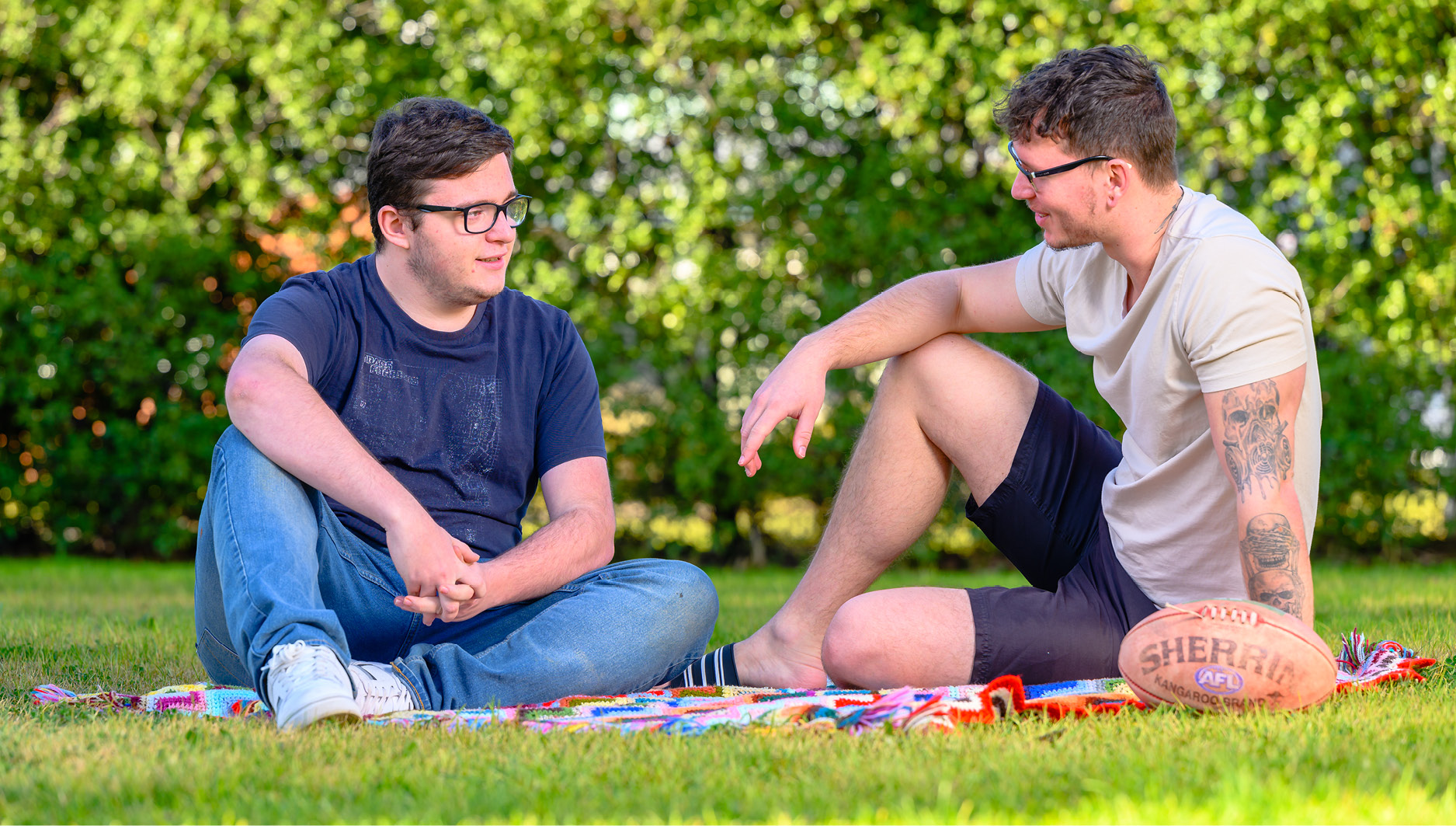 Image of 2 students relaxing on the lawn